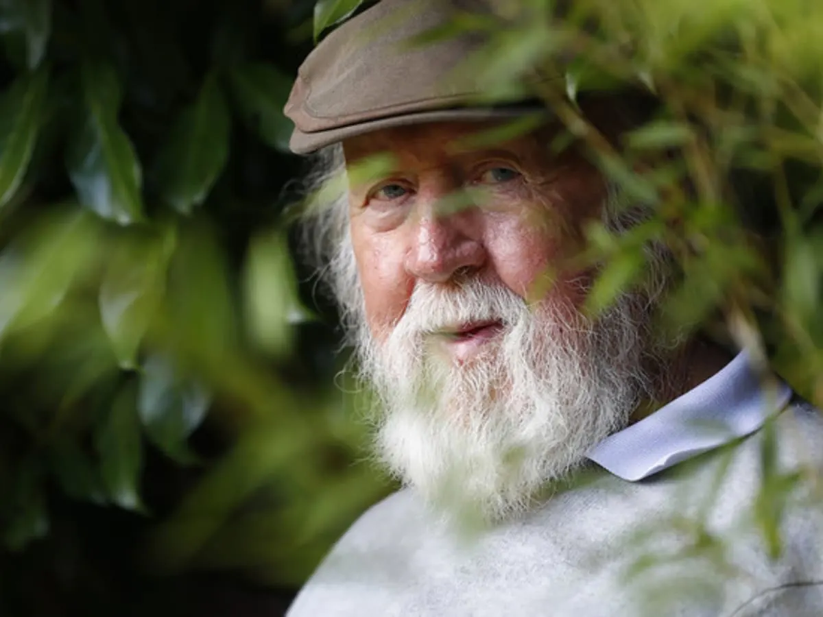 Visage de l'astrophysicien Hubert Reeves autour de quelques feuilles d'arbre