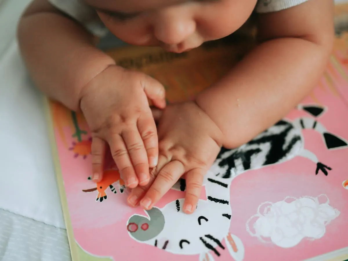 Photo d'un bébé en train de regarder les illustrations d'un livre