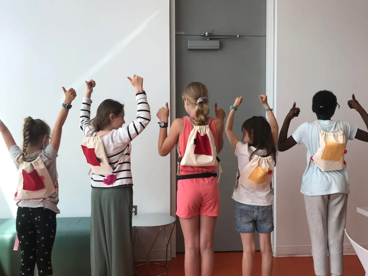 Une photo de 5 enfants portant un sac-à-dos
