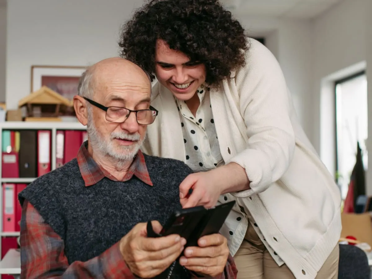 Photo de deux personnes qui utilisent un téléphone cellulaire