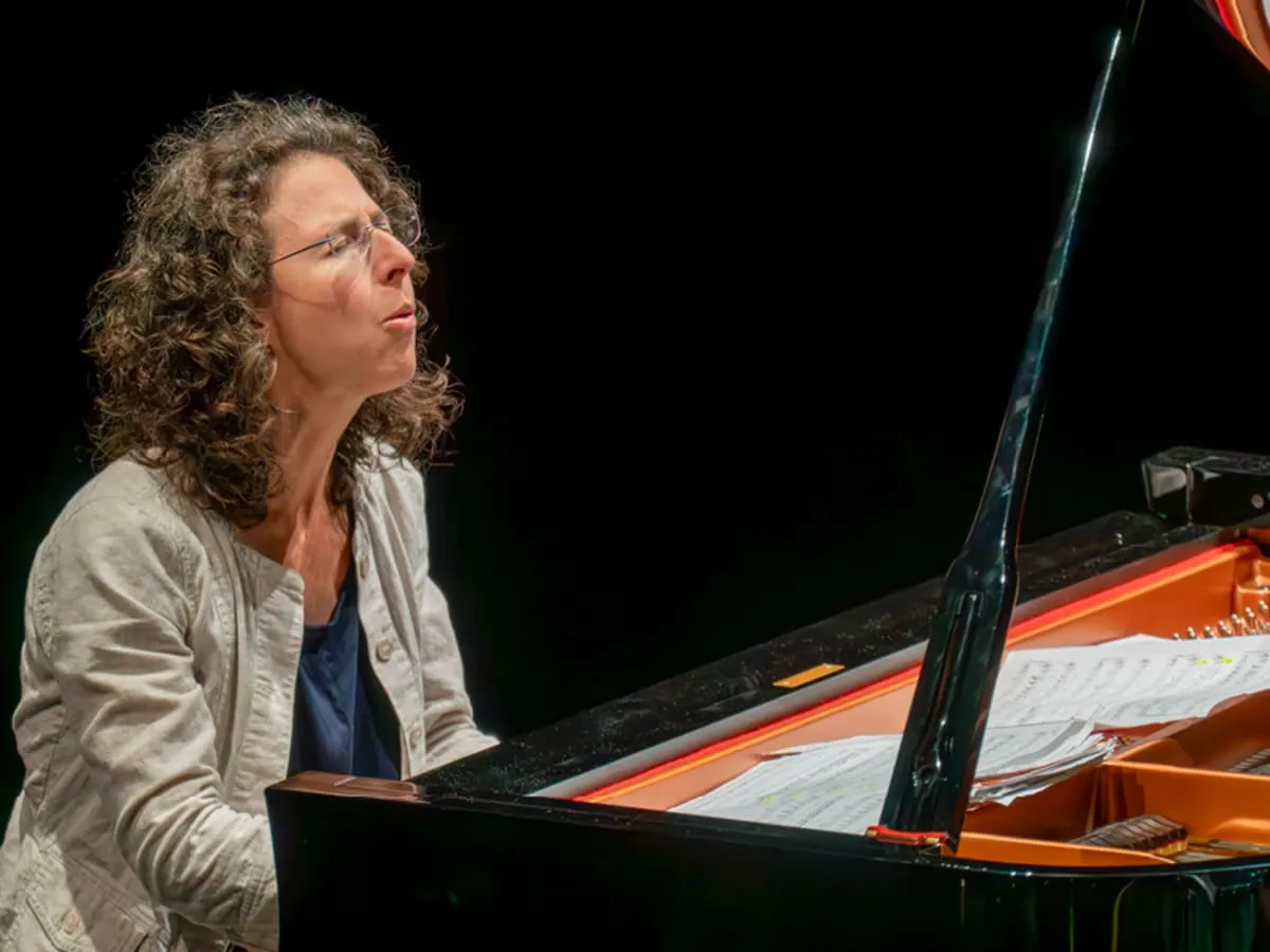 Marianne Trudel est assise au piano à queue et joue expressivement.