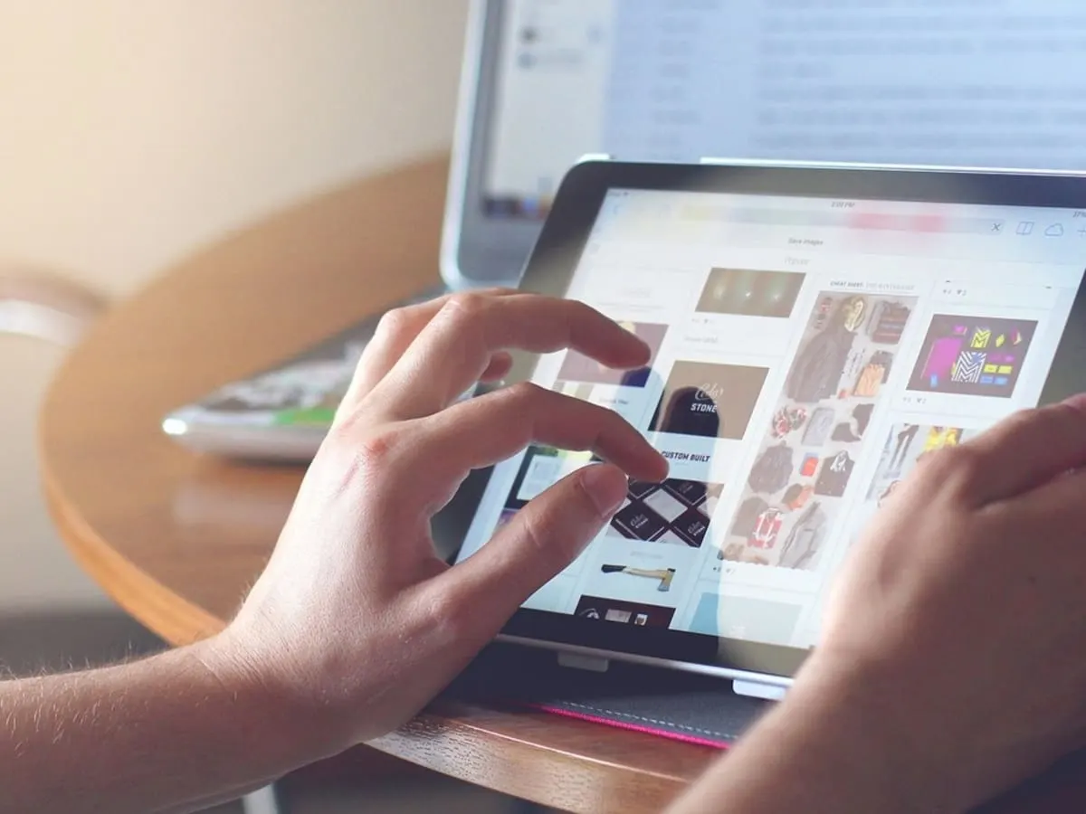 Mains qui naviguent sur une tablette.