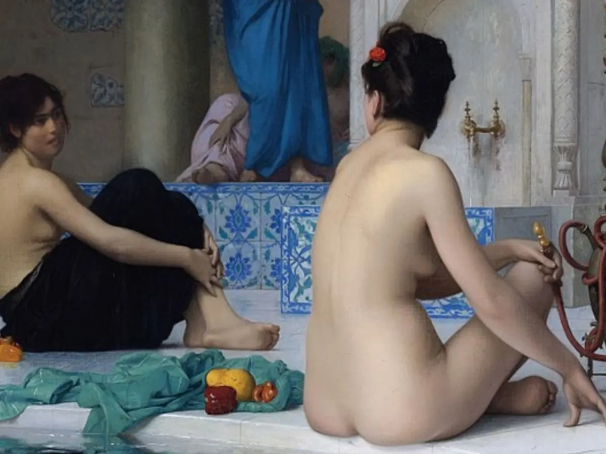 Peinture de 2 femmes en conversation dans un hammam, assises sur le sol de marbre au bord d'un bassin d'eau. La femme de droite, est de dos, nue et tient dans sa main posée sur son genou l'embout d'un narguilé. Cheveux noirs avec un rose rouge, elle tourne la tête vers la femme de gauche. Celle-ci entoure ses bras autour de ses jambes revêtus d'un tissus noir. Entre elles, un tissus vert avec des fruits. Une mosaïque blanche et bleu délimite un pallier où l'on distingue 2 femmes drapées de bleu et de rose.