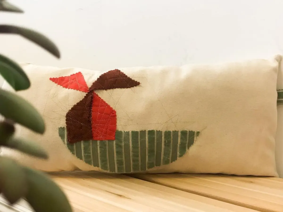 Un coussin derrière des feuilles