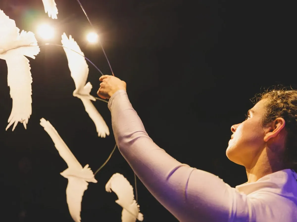 Femme qui tient des marionnettes d'oiseaux.