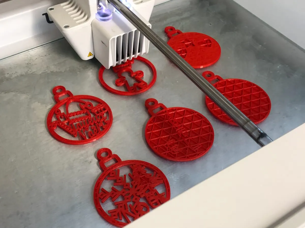 On voit des boules de Noël se faire imprimer par une imprimante 3D
