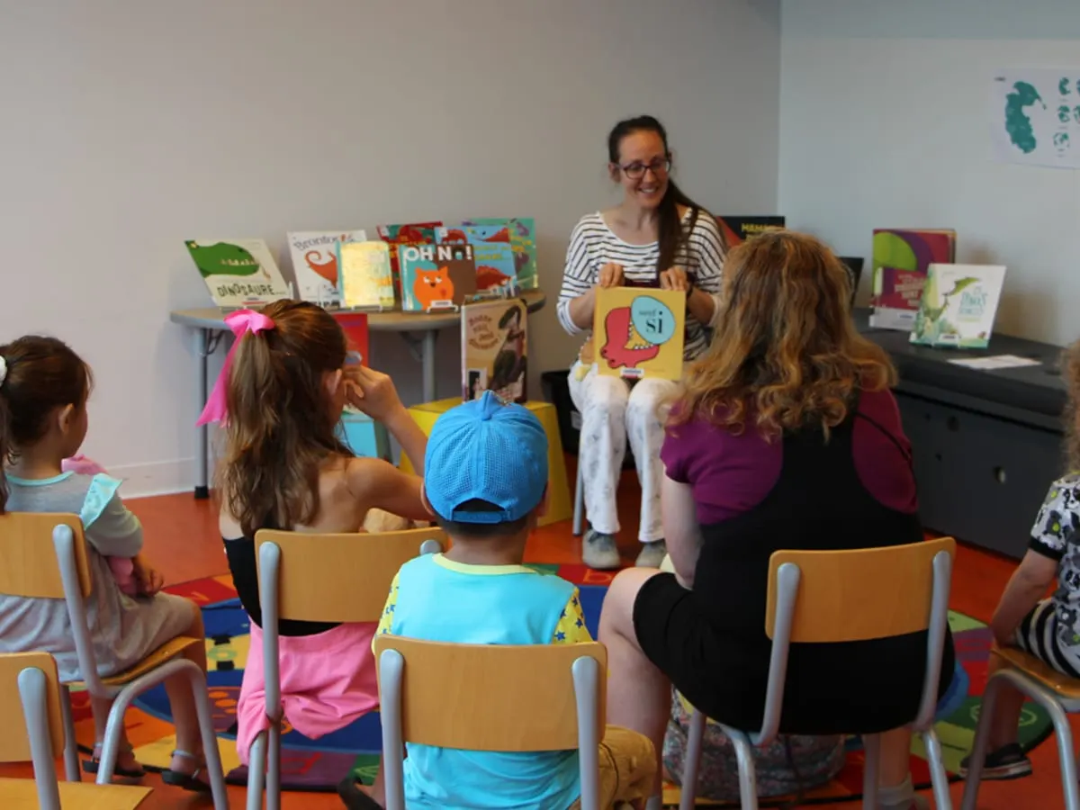 Une personne lit un livre à des enfants.