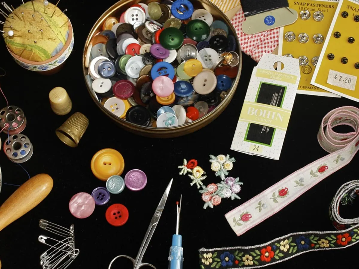Une panoplie de matériel de couture, dont du fil, des boutons, des aiguilles, des rubans, etc.
