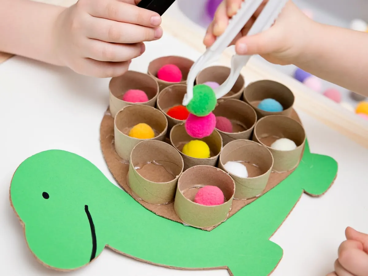 Cette image montre une activité éducative et ludique réalisée avec du matériel de bricolage recyclé.