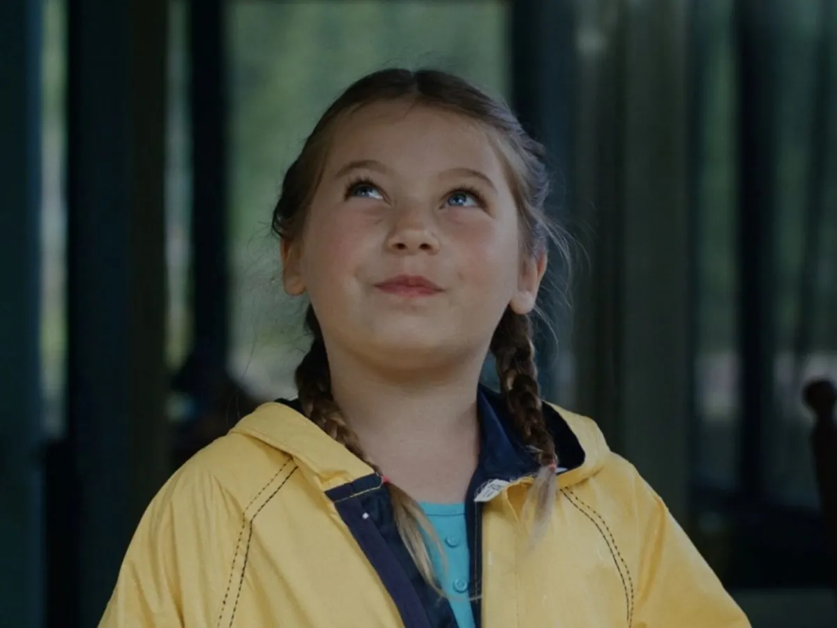 Petite fille réfléchissant, les yeux en l'air.