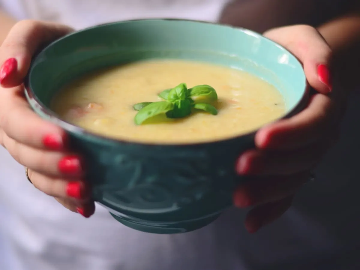 Photo d'une personne tenant un bol de soupe dans les mains