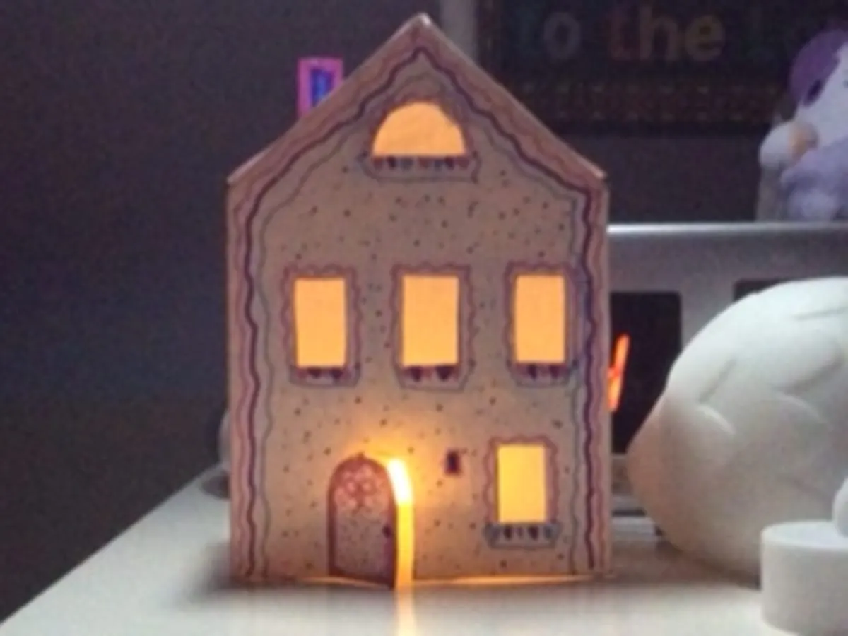 une maison faite en papier qui s'illumine