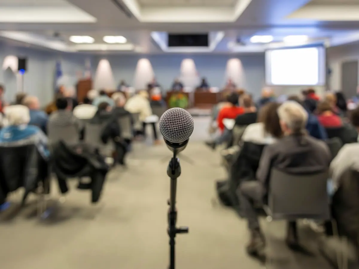 Micro et citoyens dans la salle du conseil d'arrondissement